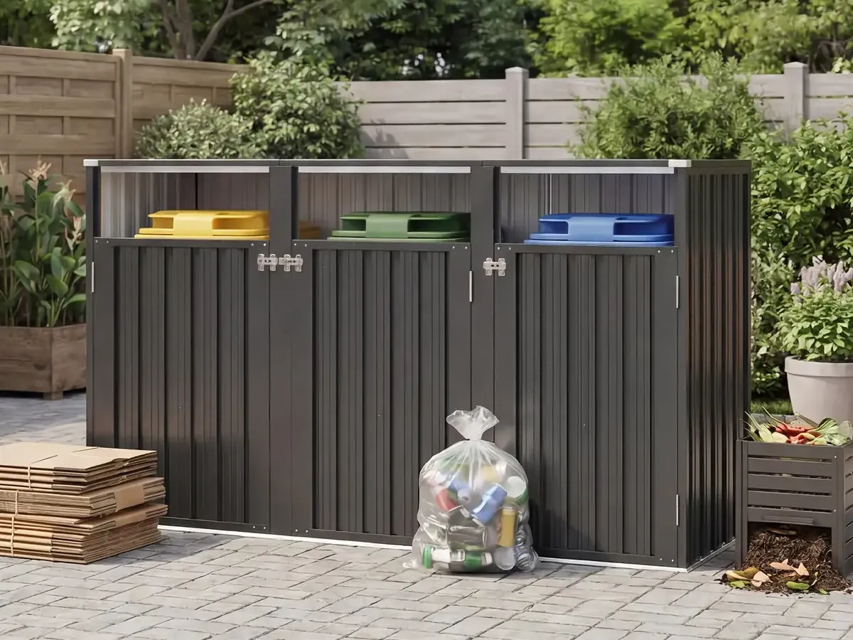 Dark gray metal enclosure for three trash bins on a paved patio.